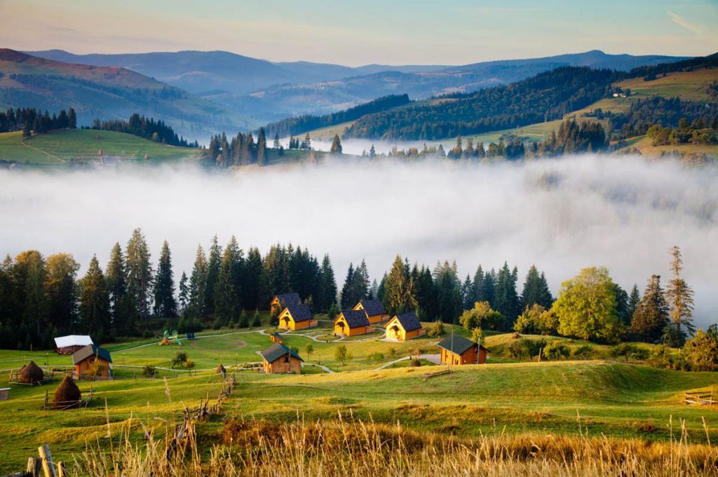Carpathian village between mountains and morning fog