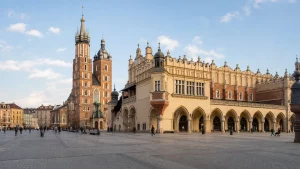 Сукенниці та Маріацький костел на Ринковій площі Кракова, Польща, у теплому денному світлі.